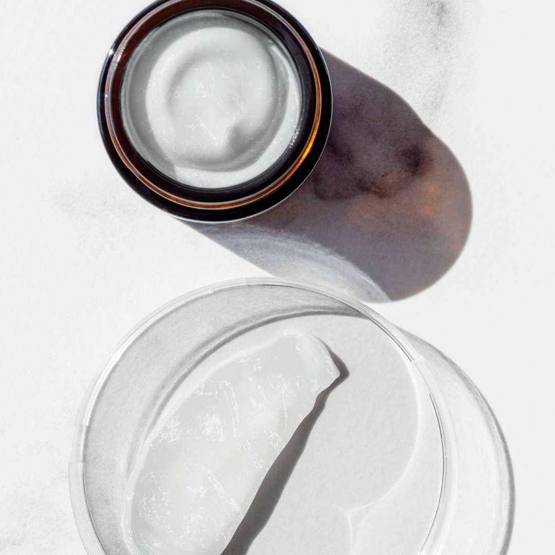 Textură de cremă hidratantă într-un borcan de sticlă, cu aplicare ușoară și consistență lejeră.